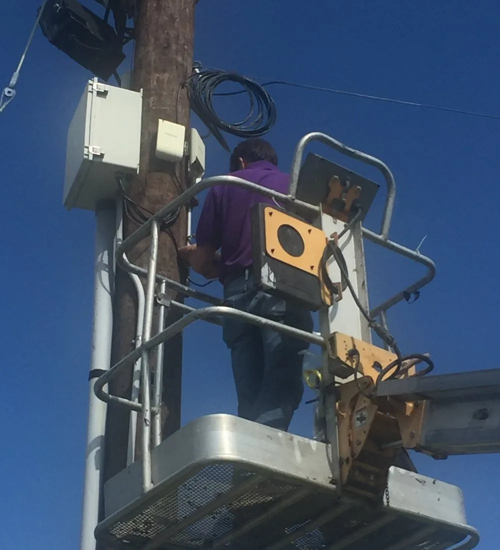 A Guardian technician mounting a wireless access point from a bucket lift